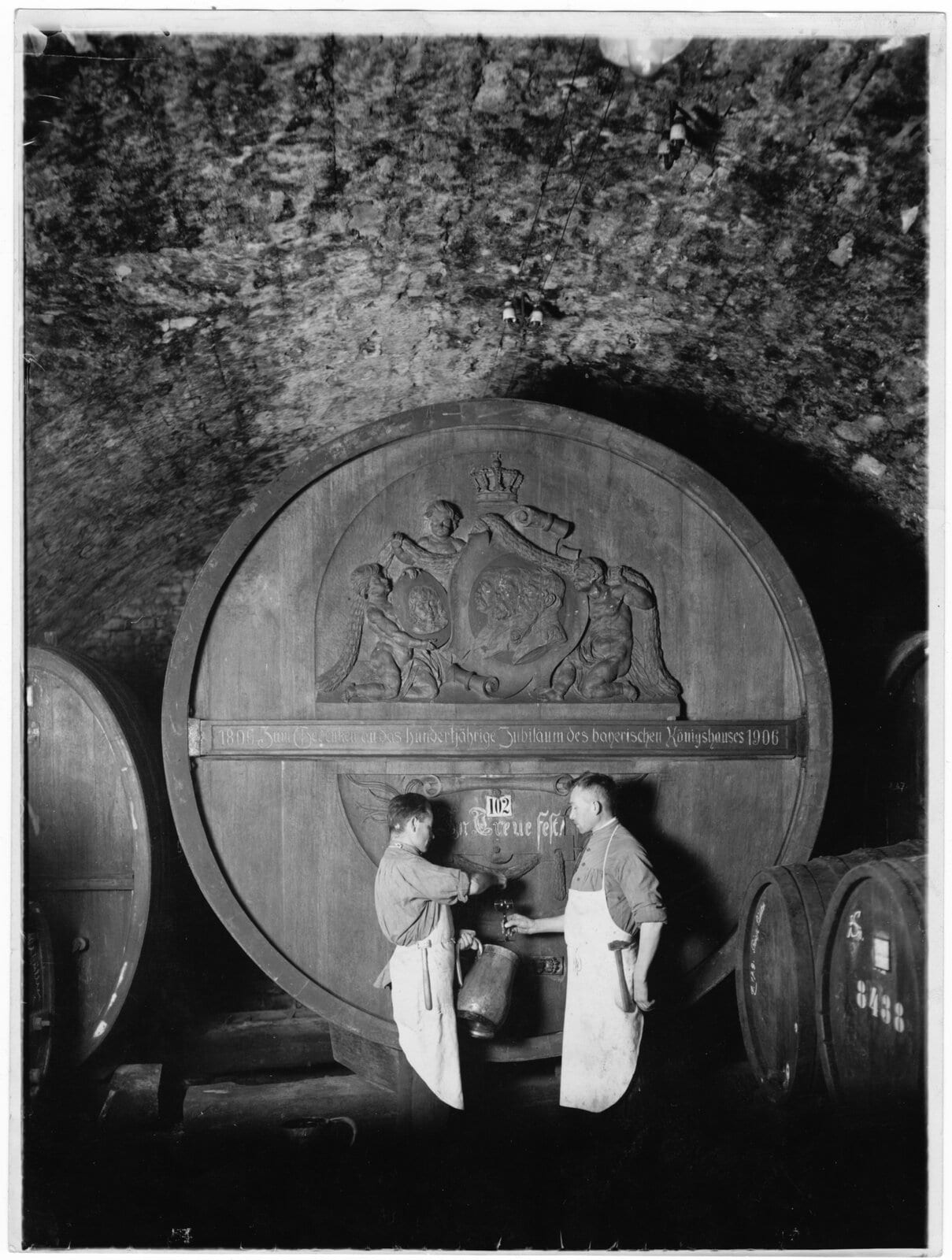 Historisches Foto zweier Kellermeister am Wittelsbacher Faß im Kellergewölbe